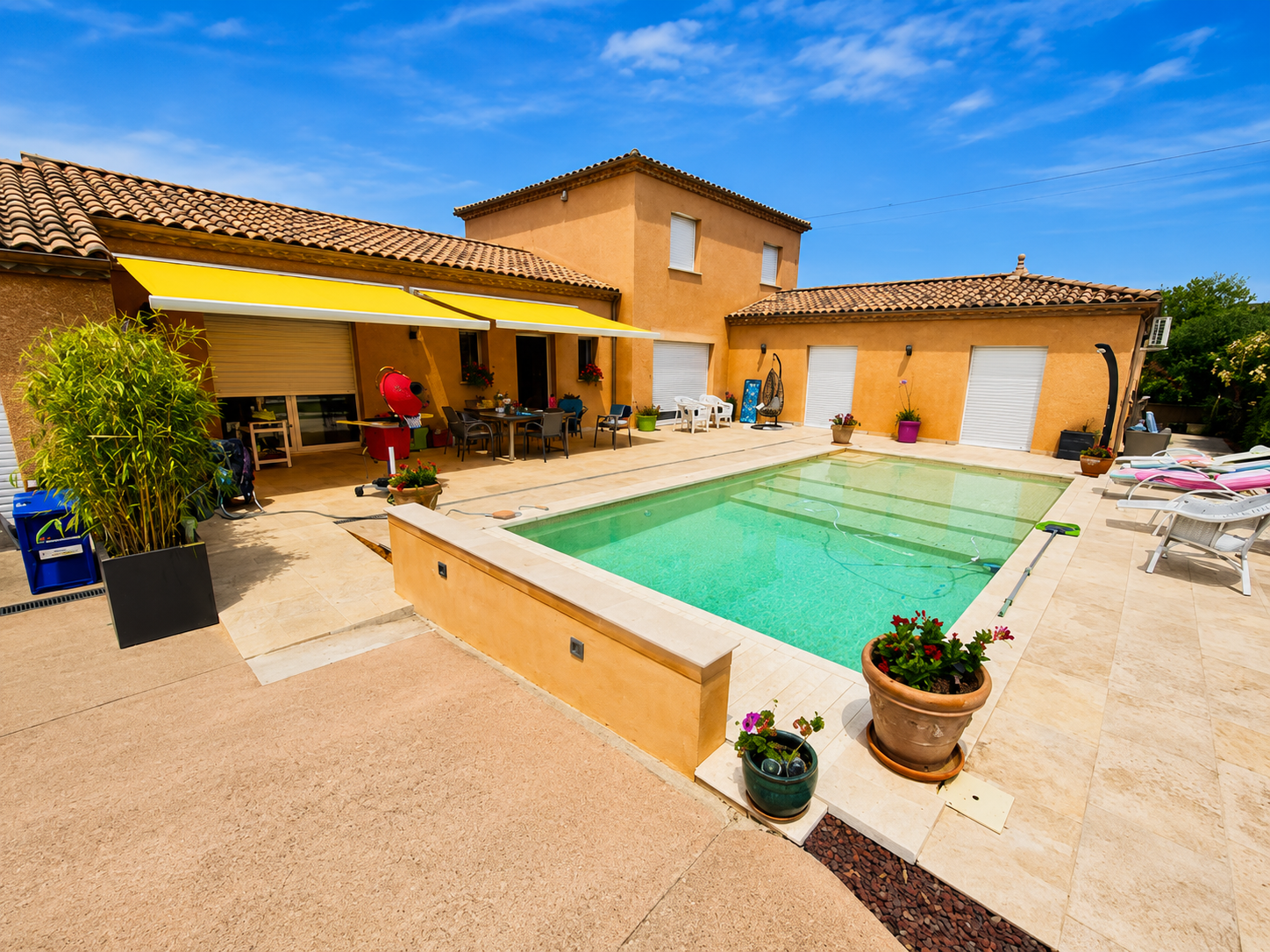 Façade ensoleillée et piscine du domaine